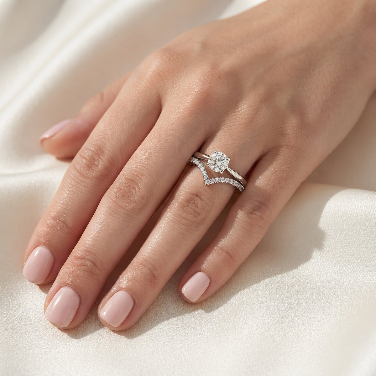 18k white gold diamond wishbone half eternity ring worn with a diamond solitaire
