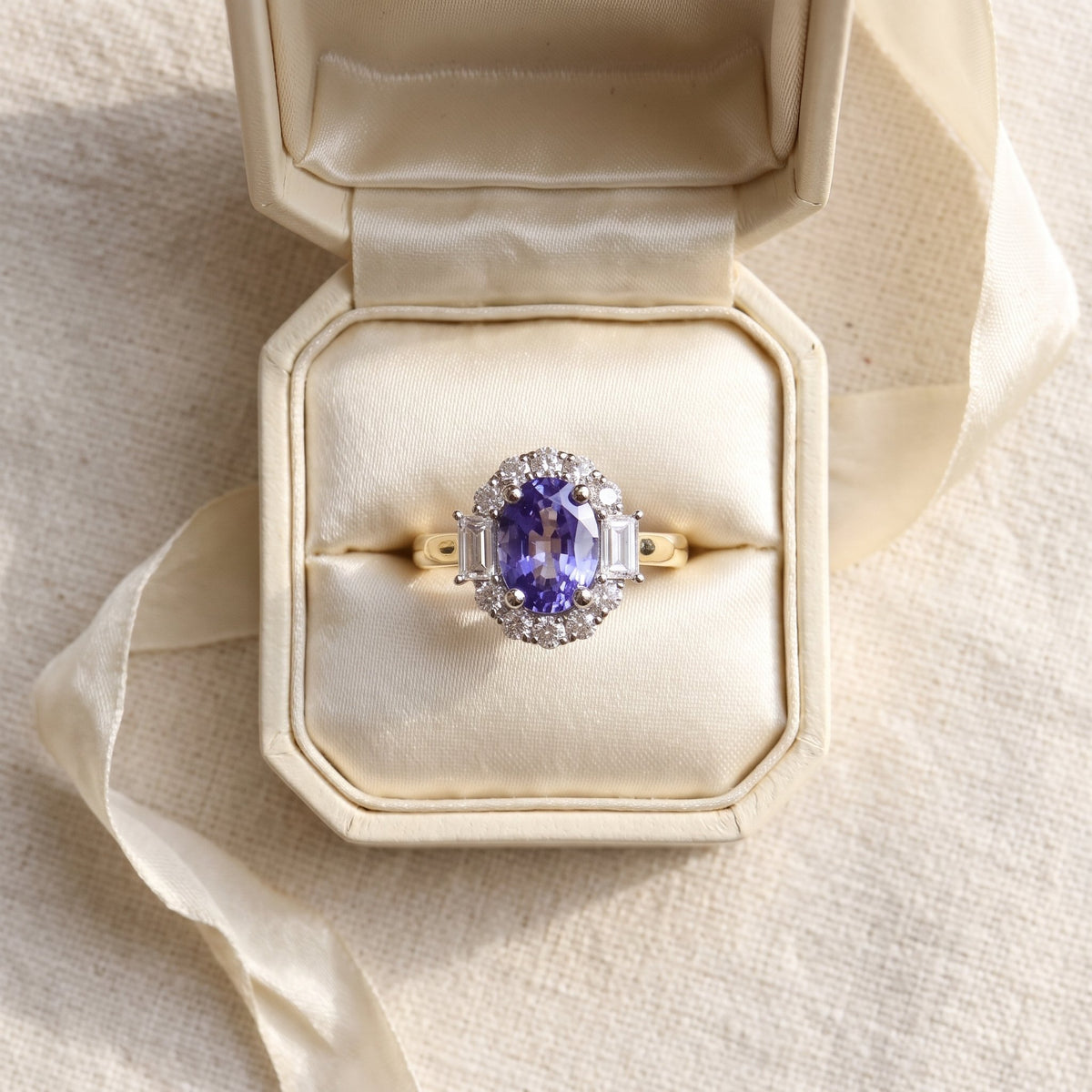 Yellow sapphire and diamond emerald cut cluster ring in 18k yellow gold, in an ivory ring box
