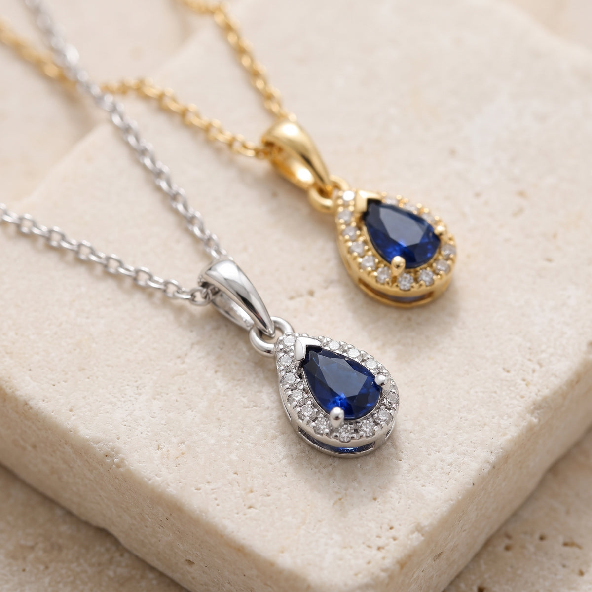 Pear blue sapphire and diamond halo pendants in 18k white and yellow gold