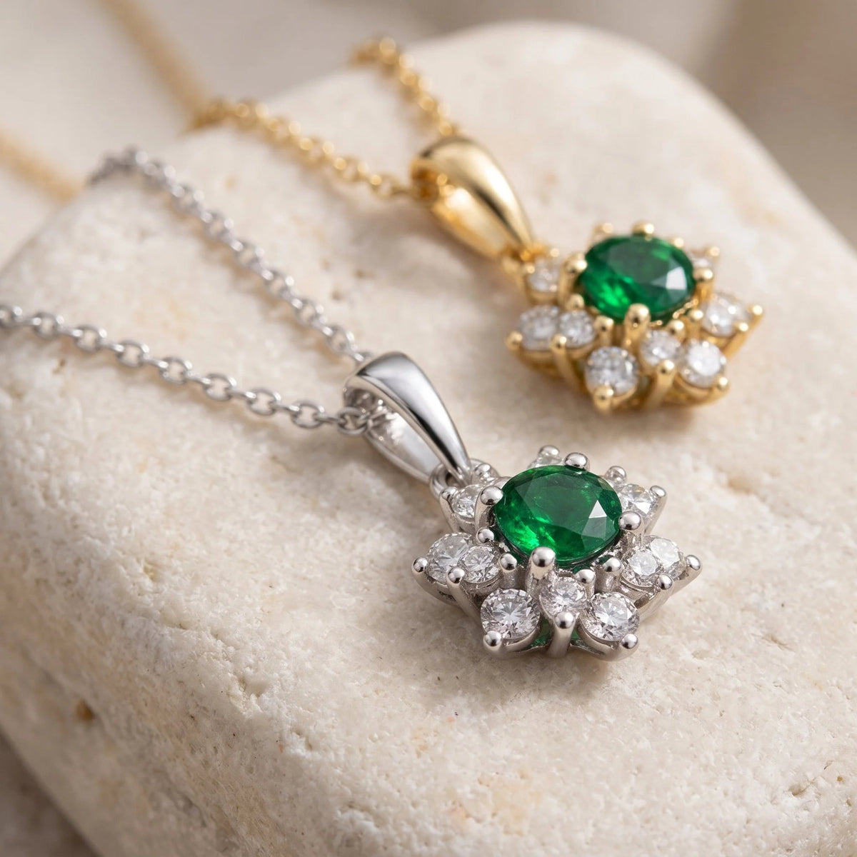 Round emerald and diamond cluster pendants in 18k white gold and 18k yellow gold