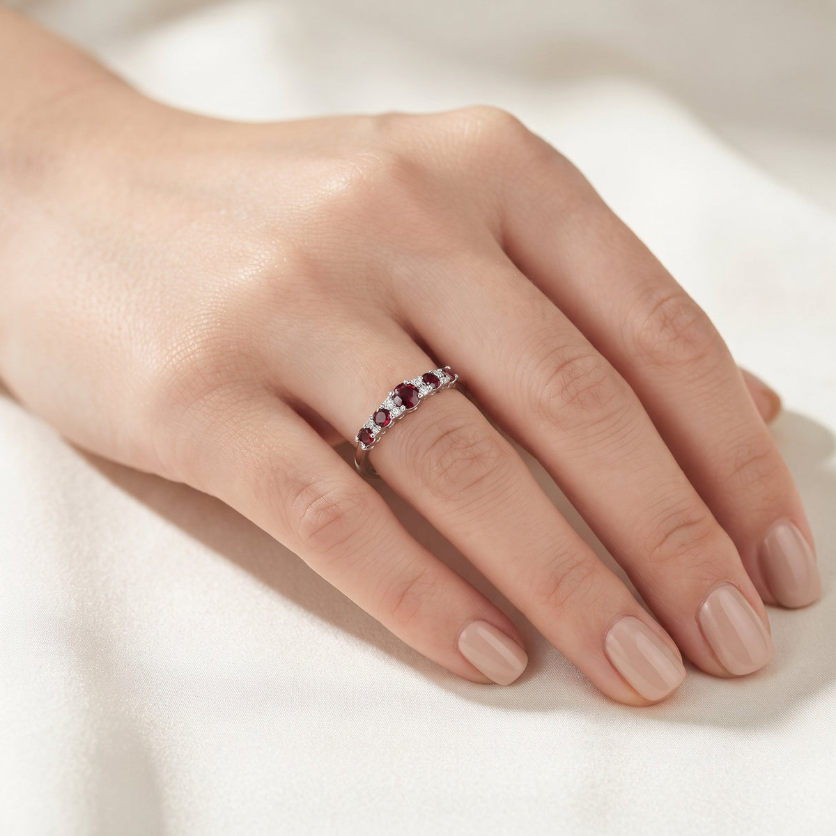 18k white gold ruby and diamond graduated five stone ring worn on the hand