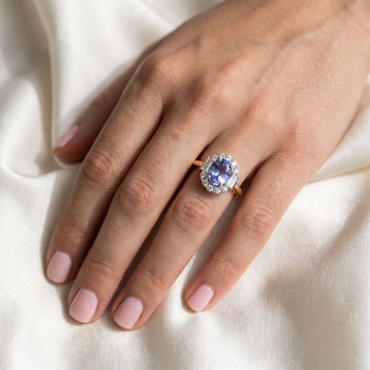Purple sapphire and diamond oval halo ring in 18k yellow gold and platinum, worn on the hand