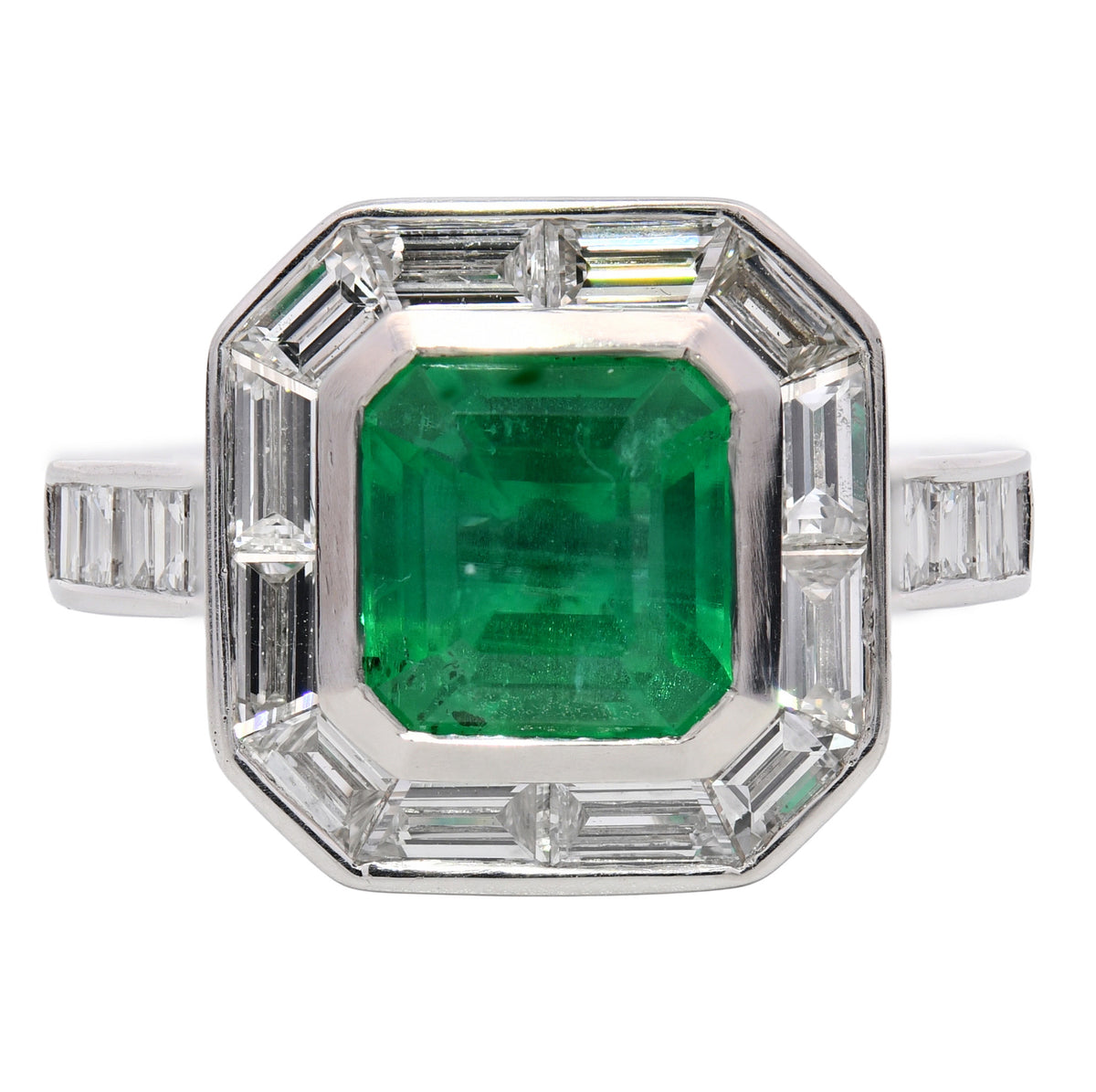 Emerald and diamond halo ring in platinum