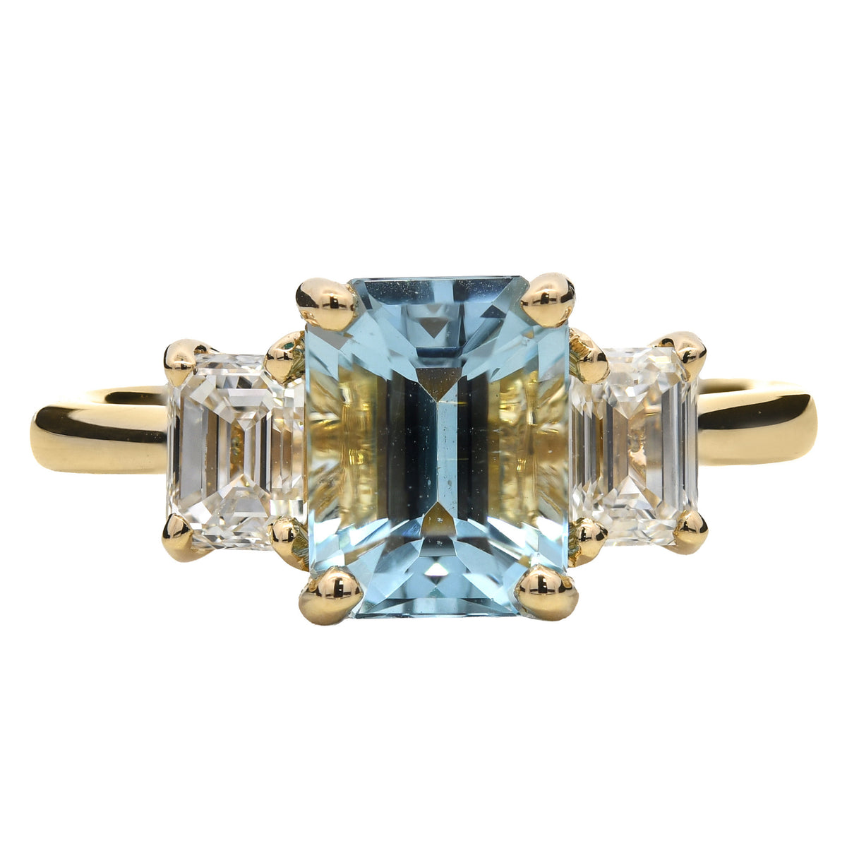 Aquamarine and emerald cut diamond three stone ring in 18k yellow gold