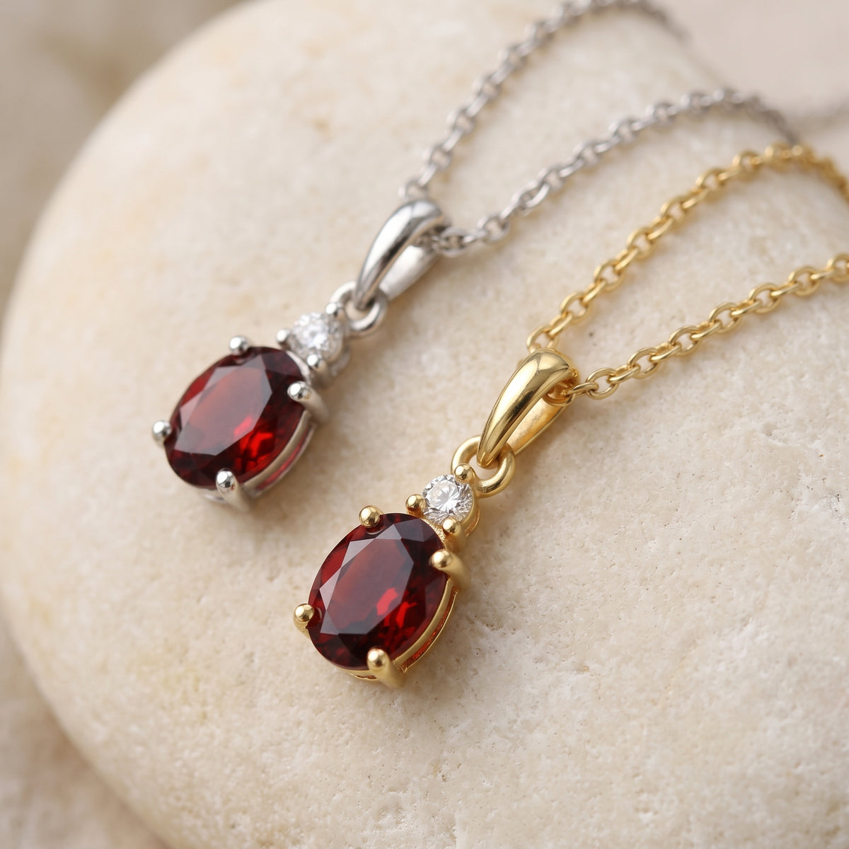 Oval garnet and diamond drop pendants in 18k white and yellow gold