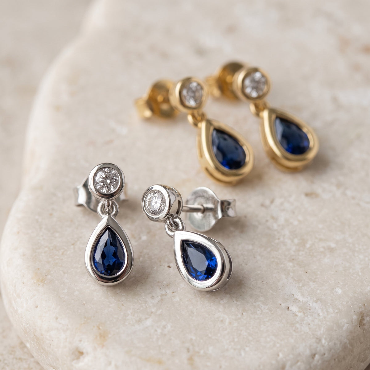 Pear sapphire and diamond rubover drop earrings in 18k white and yellow gold