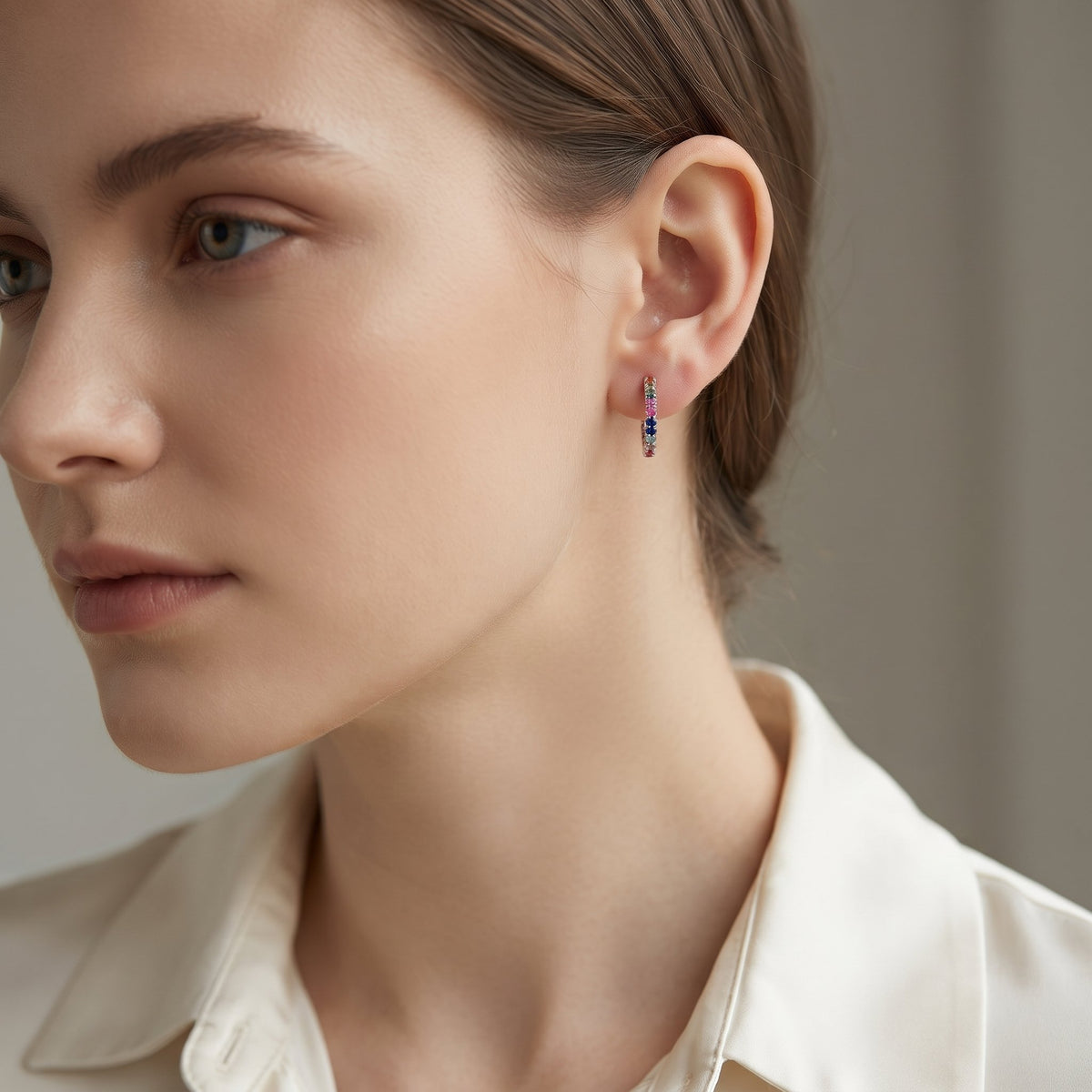 18k white gold rainbow sapphire hoop earring worn on the ear
